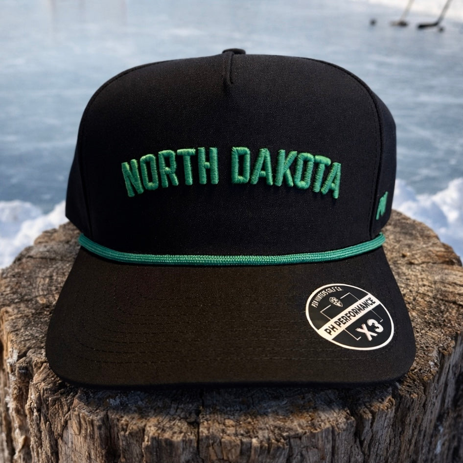 Close-up side detail of the black North Dakota Performance Hat showing green PH embroidery, perforated side panels, and green rope accent.