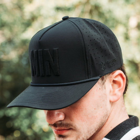 Black tonal MIN performance golf hat with raised black embroidery, matching rope detail, perforated side panels, and side logo.