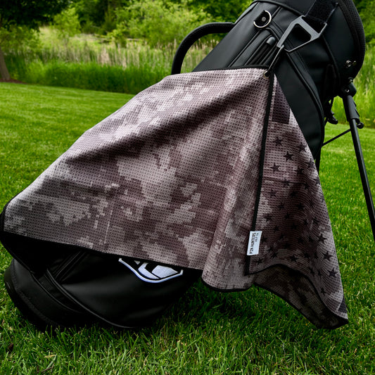 USA camo golf towel hanging on a black golf bag with black digital camo pattern, black star accents, and black edging.