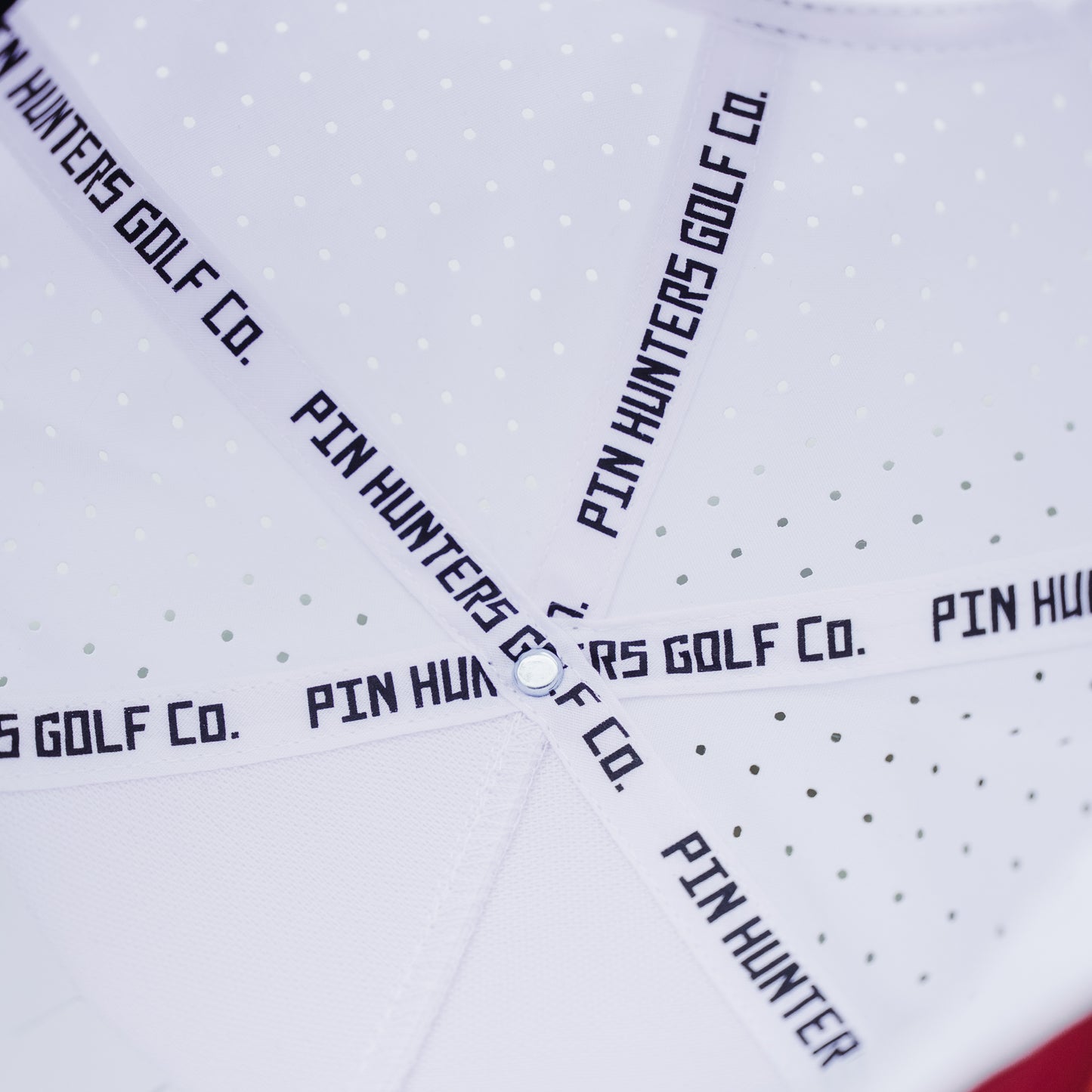 Interior of white performance hat showing Pin Hunters Golf Co branded seam tape and perforated panels.
