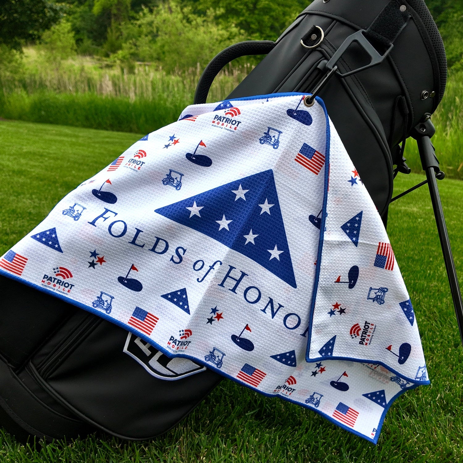 A beautiful, Folds of Honor custom magnetic golf waffle towel hanging on a black Pin hunters golf bag