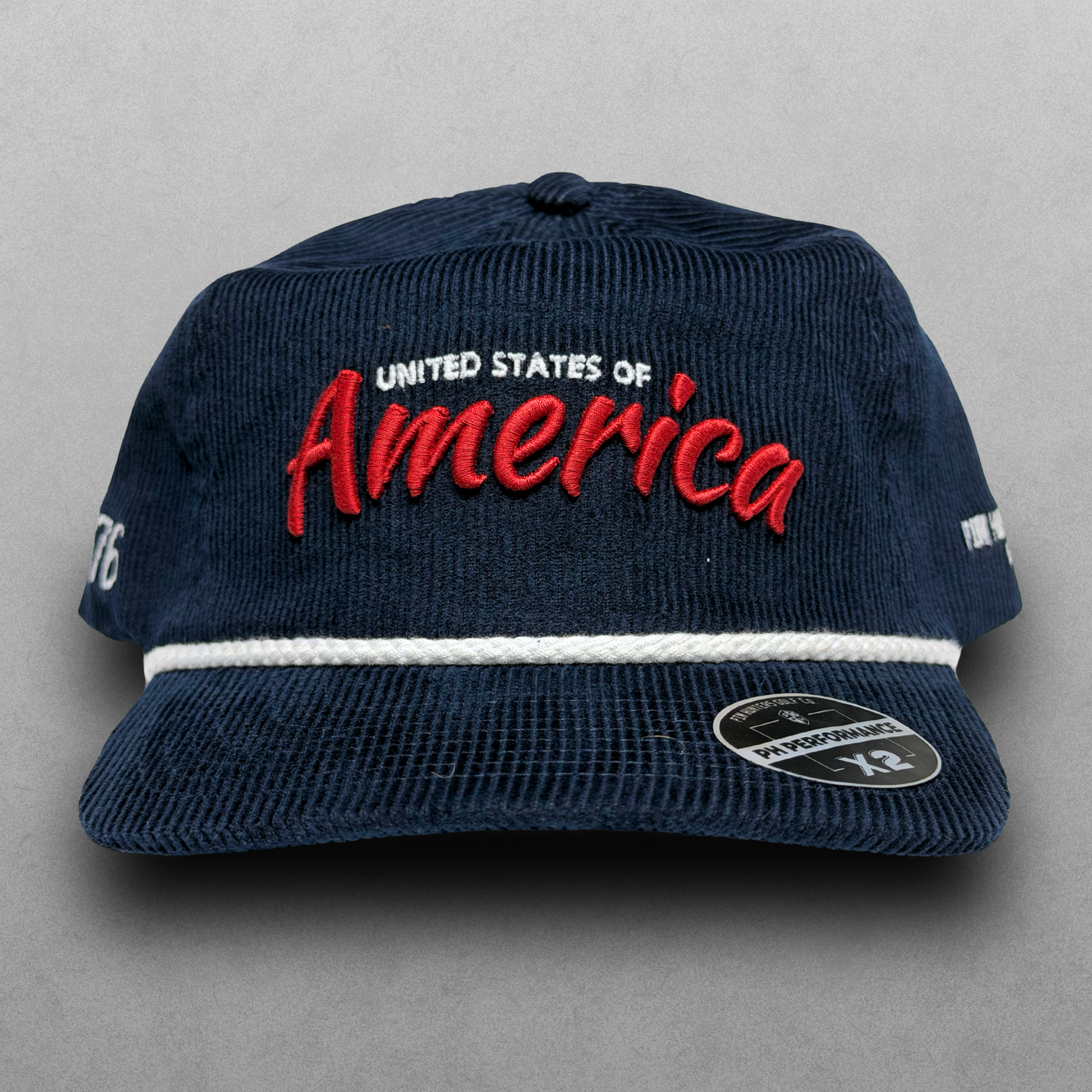 Navy corduroy America hat with red script embroidery, white United States of America text, white rope detail, and PH Performance X2 sticker.