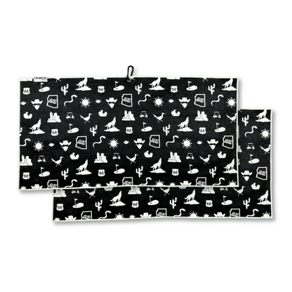 Black Arizona themed golf towel product image with white cactus, desert, road sign, sun, golf cart, golfer, and golf flag icons.