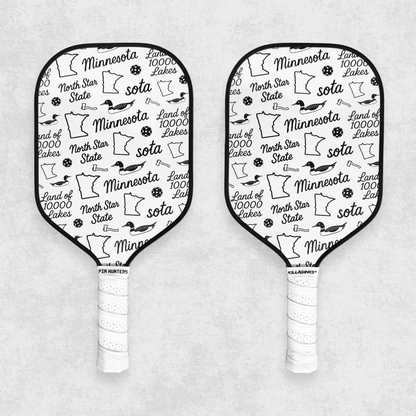 Black and white Minnesota pickleball paddle set with state icons, loons, pickleballs, and white grips on a gray textured background.