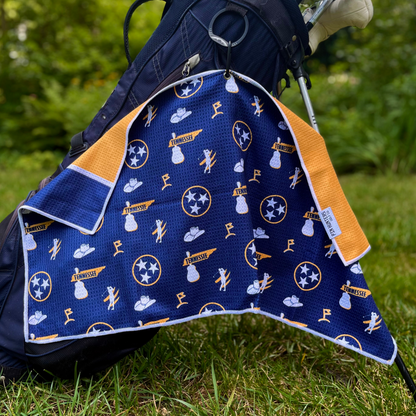 Blue nashville predators inspired golf towel hanging from a golf bag with Tennessee state, TriStar, music, cowboy hat, and golf graphics.