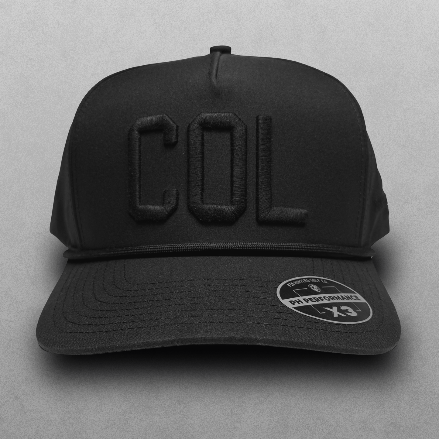 Blackout COL performance hat with tonal black raised embroidery, black rope detail, and PH Performance X3 sticker.