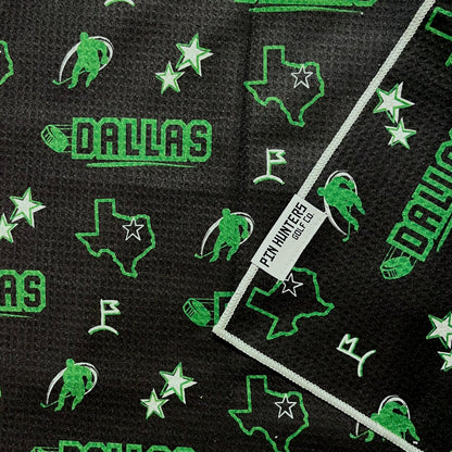 Dallas Stars hockey golf towel close-up with black waffle microfiber, green Dallas text, Texas outlines, stars, and hockey player icons.