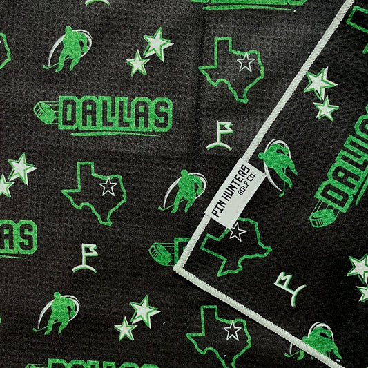 Dallas Stars hockey golf towel close-up with black waffle microfiber, green Dallas text, Texas outlines, stars, and hockey player icons.