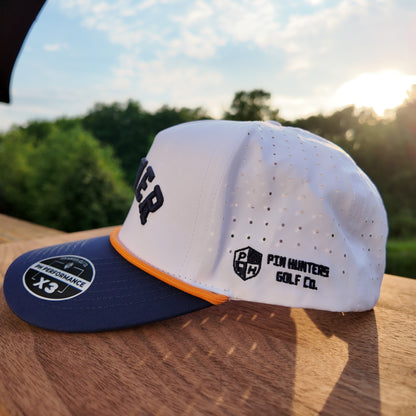 Side profile of the Denver performance golf hat with white crown, navy brim, orange rope, perforated side panels, and Pin Hunters side logo.