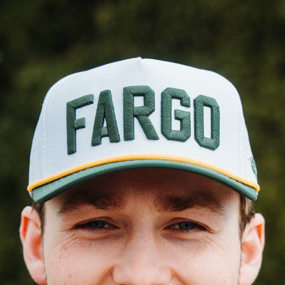 White Fargo performance golf hat with green raised FARGO embroidery, gold rope, green brim, and perforated side panels.