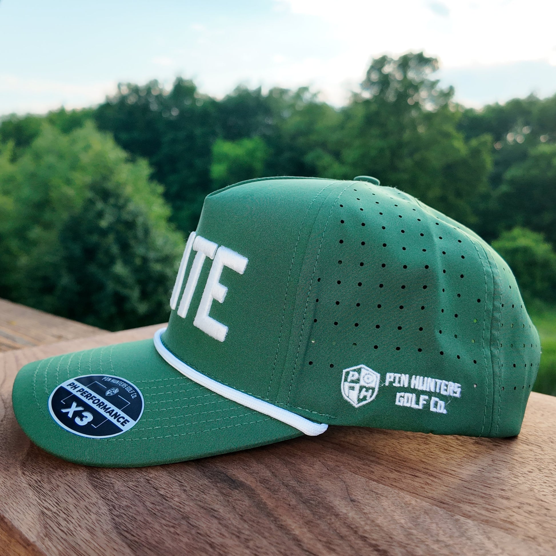 Side profile of the Michigan State green performance golf hat with white rope, perforated side panels, Pin Hunters side logo, and flat brim.