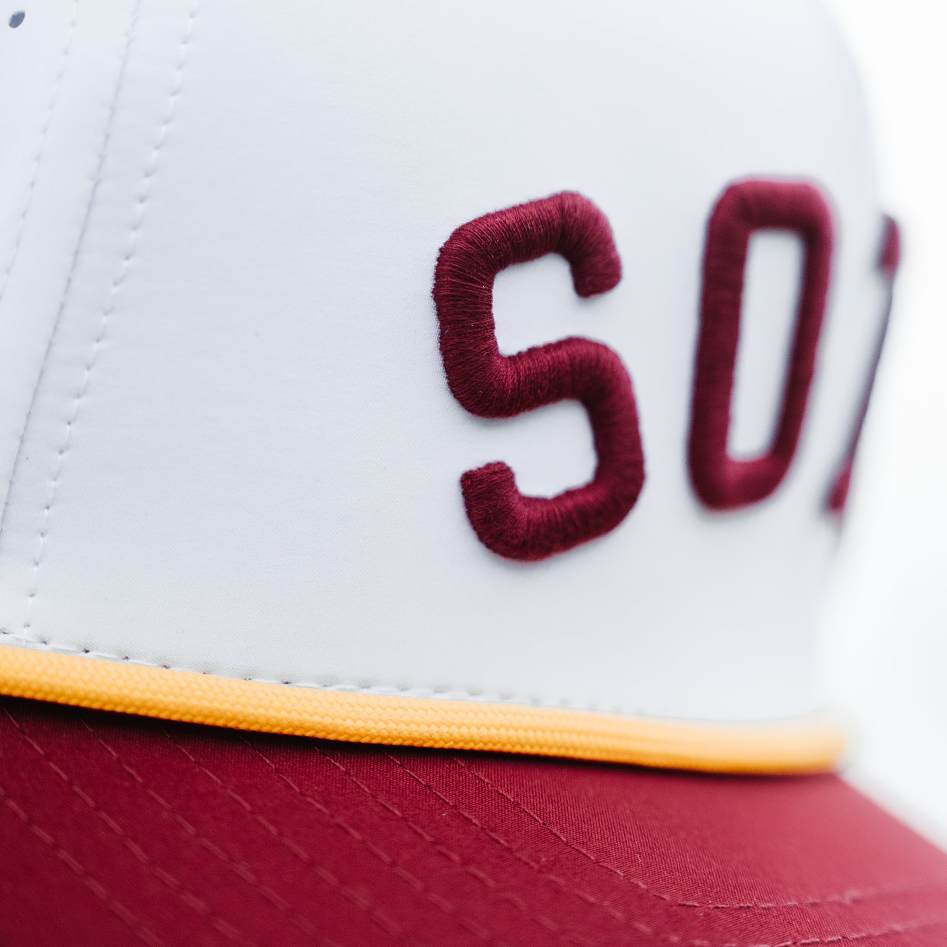 Minnesota Golden Gophers SOTA performance hat close-up with maroon raised embroidery, white crown, yellow rope, and maroon brim.