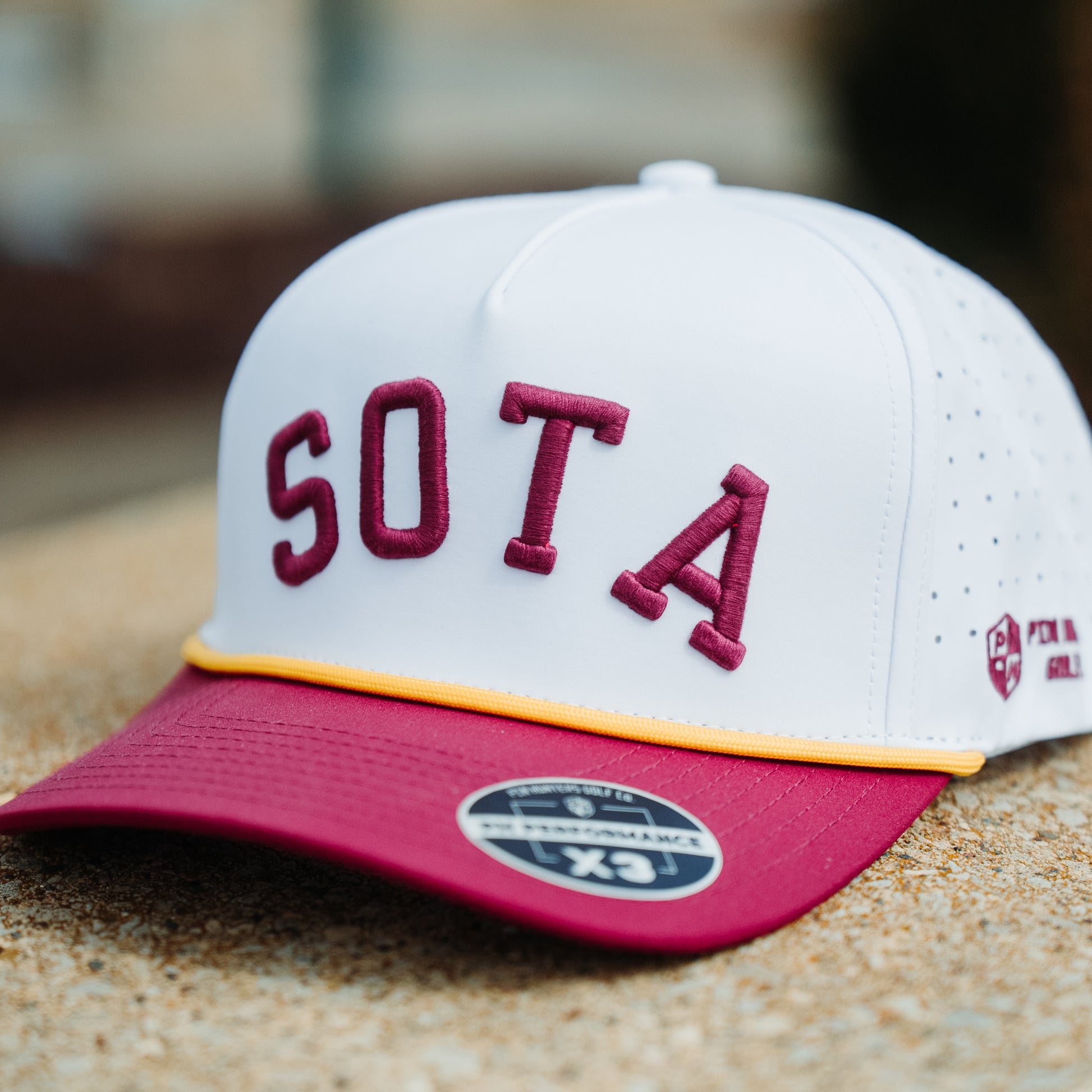 Minnesota Golden Gophers SOTA performance hat with white crown, maroon raised embroidery, maroon brim, yellow rope, and perforated side panels.