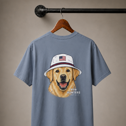 Blue Jean Pin Hunters Colby Tee on a wooden hanger featuring a golden retriever wearing a patriotic golf hat.