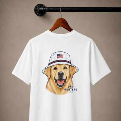 White Pin Hunters Colby Tee hanging on a wooden hanger with golden retriever in patriotic golf hat graphic on the back.