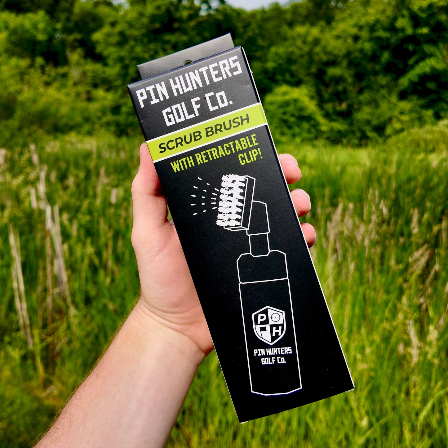 Front of the Pin Hunters Golf Co. scrub brush retail box with product illustration, logo, and retractable clip callout.