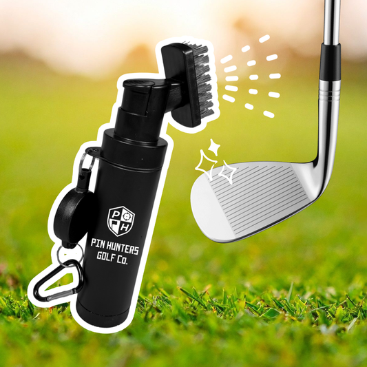 Pin Hunters Golf Co. scrub brush shown next to a golf club face with spray and scrub graphics on a grass background.
