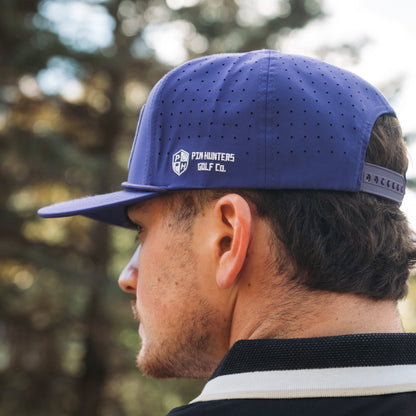Side and back view of the purple Minnesota Vikings MIN Performance Hat by Pin Hunters Golf Co. showing perforated panels, side logo embroidery, and adjustable snapback fit.