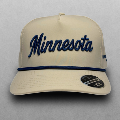 Studio front view of tan Minnesota script performance golf hat with navy embroidery, navy rope, flat brim, and PH Performance X3 sticker.