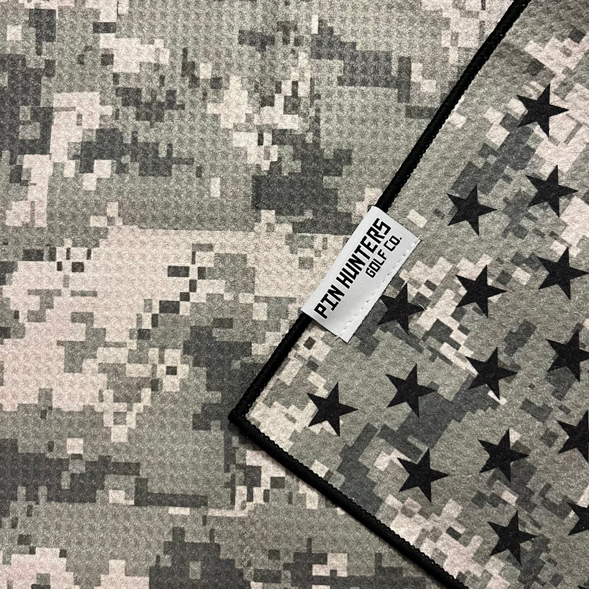 Close up of USA camo flag golf towel with black, gray, and white stars, stripes, digital camo, and Pin Hunters Golf Co. label.