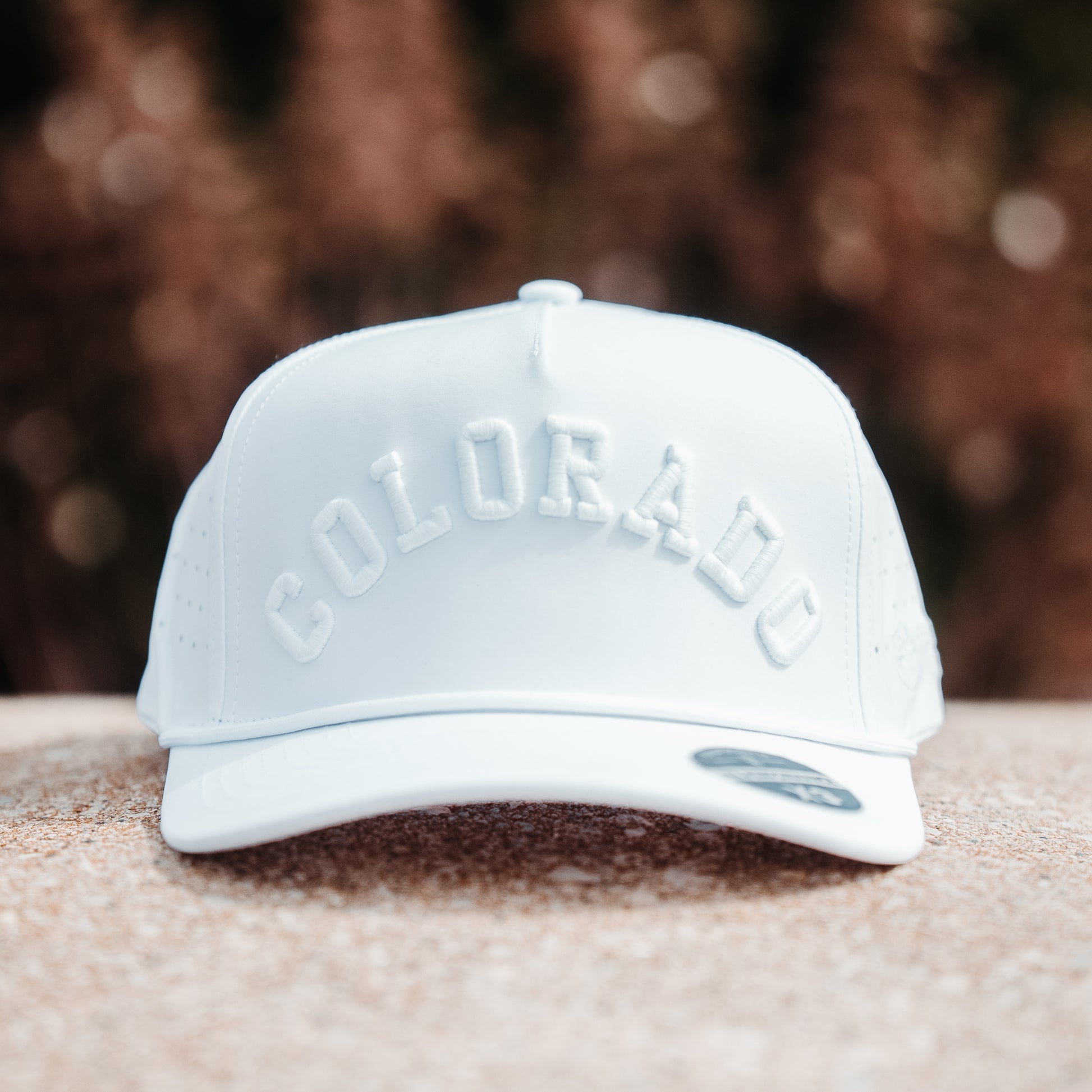 White Colorado performance golf hat front view with tonal white raised embroidery, matching rope detail, and PH Performance X3 sticker.