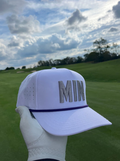 White MIN performance golf hat with gray raised embroidery, purple rope, perforated sides, and golf course background.