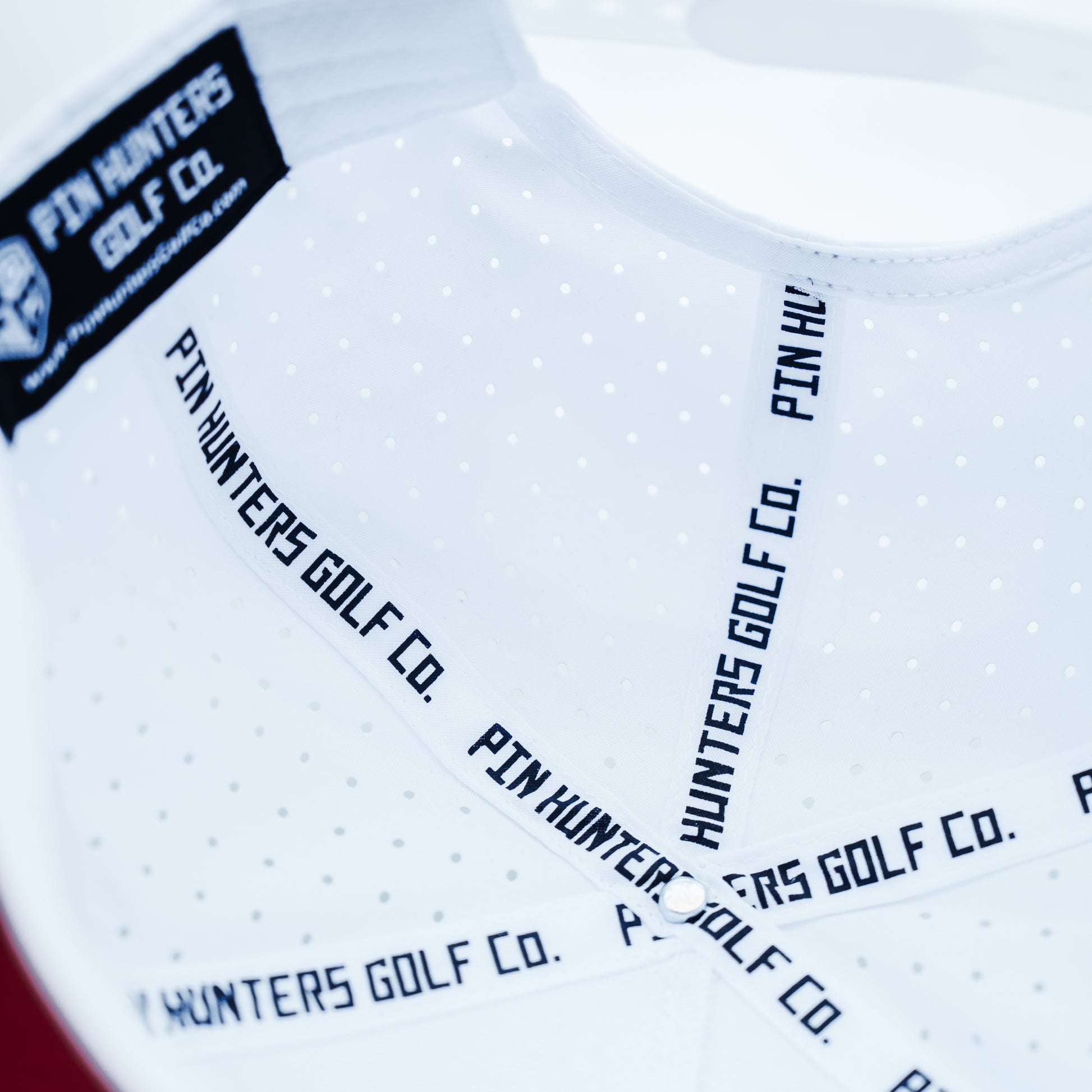 White Pin Hunters performance golf hat interior with branded seam tape, perforated panels, black inner label, and clean structured construction.