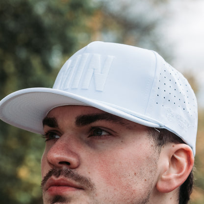 White tonal MIN performance golf hat close-up showing white embroidery, perforated side panels, matching rope detail, and side logo.