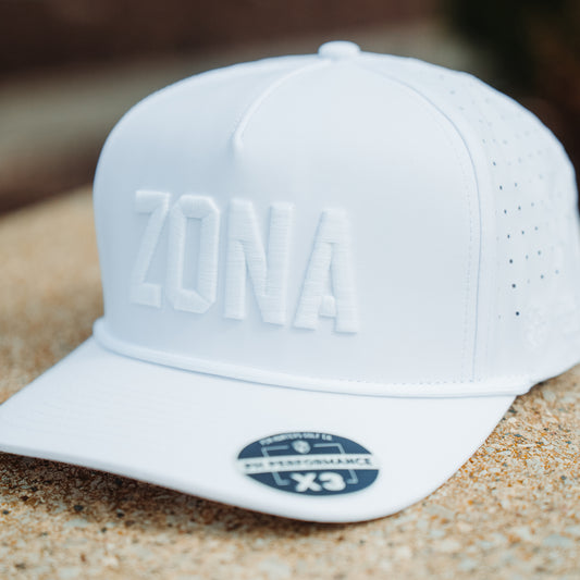 Whiteout Zona performance hat front angle with tonal white ZONA raised embroidery, white rope detail, perforated side panels, and PH Performance X3 sticker.